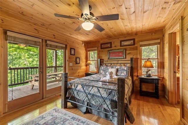 bedroom with hardwood / wood-style floors, access to exterior, and multiple windows
