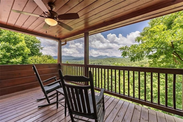 wooden terrace with a ceiling fan and a mountain view