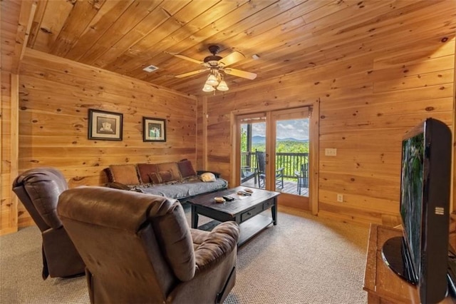 living area featuring ceiling fan, carpet flooring, wood ceiling, and wood walls