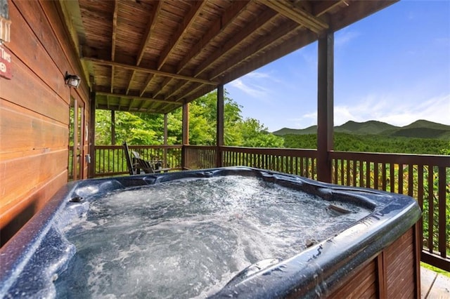 wooden terrace featuring a hot tub and a mountain view