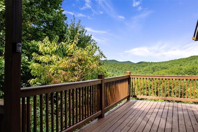 wooden terrace with a forest view and a mountain view