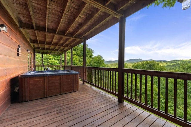 wooden deck featuring a hot tub and a mountain view