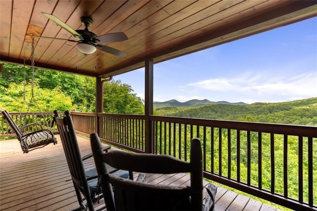wooden terrace with a ceiling fan and a mountain view