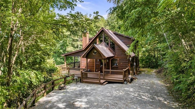 rustic home featuring a wooden deck and a chimney