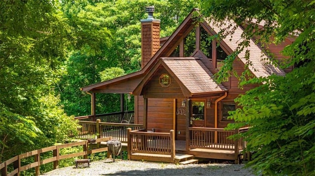 rear view of property featuring a chimney and a deck