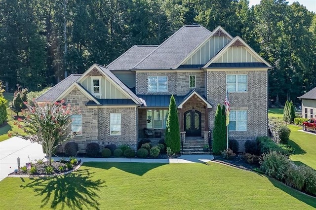 craftsman-style home with stone siding, a front lawn, and board and batten siding