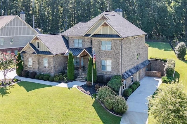 craftsman-style home featuring metal roof, a front lawn, and a standing seam roof