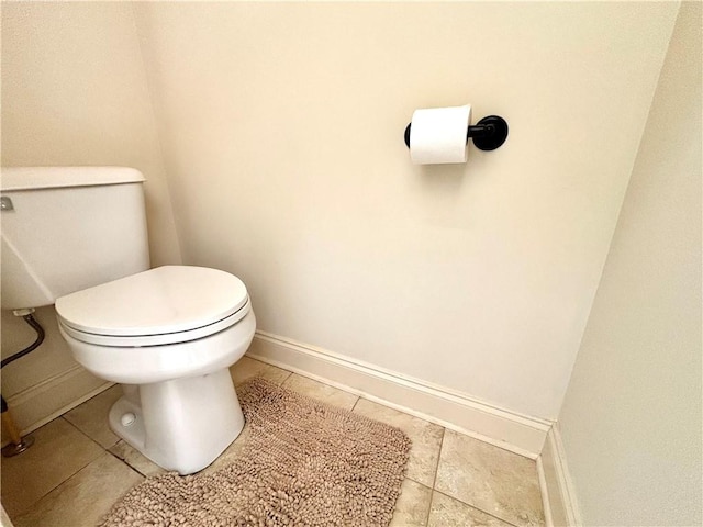 bathroom with tile patterned floors, baseboards, and toilet