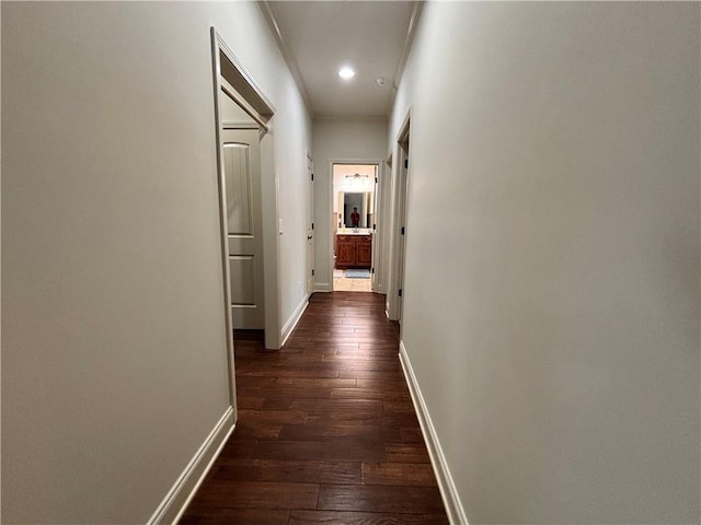 corridor featuring dark wood finished floors, recessed lighting, and baseboards