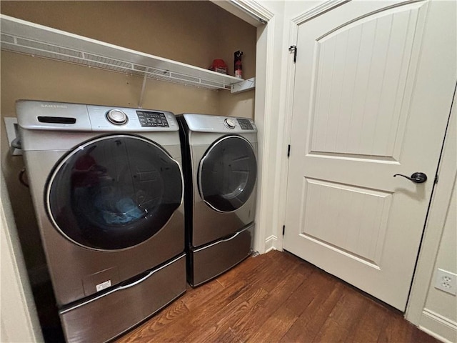 washroom with dark wood finished floors, laundry area, and separate washer and dryer