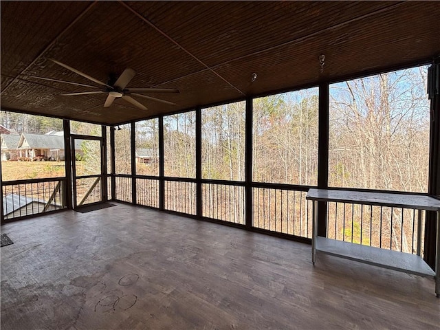 unfurnished sunroom featuring wood ceiling and a ceiling fan