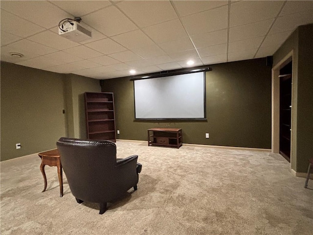 cinema room featuring a paneled ceiling, baseboards, and carpet floors