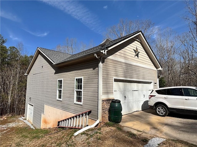 view of property exterior with concrete driveway, an attached garage, and roof with shingles