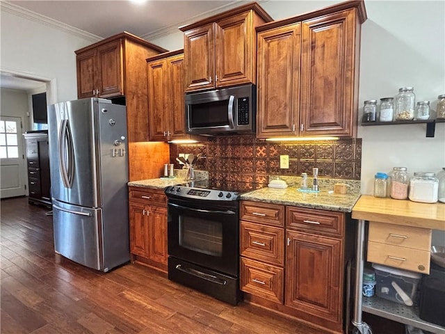 kitchen featuring crown molding, dark wood-type flooring, light stone countertops, decorative backsplash, and appliances with stainless steel finishes