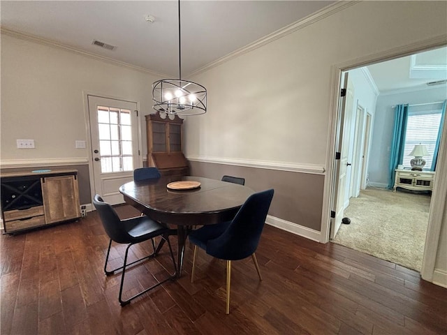 dining area featuring dark wood-style floors, visible vents, crown molding, and baseboards