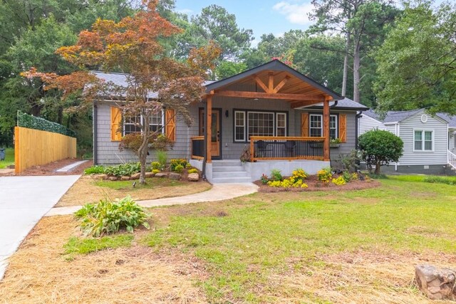 bungalow featuring covered porch and a front lawn