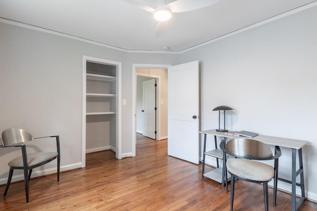 office featuring built in features, ceiling fan, wood-type flooring, and ornamental molding