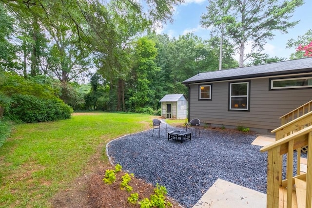 view of yard featuring a patio, a shed, and a fire pit