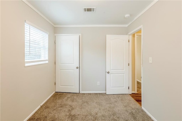 unfurnished bedroom featuring ornamental molding and light colored carpet