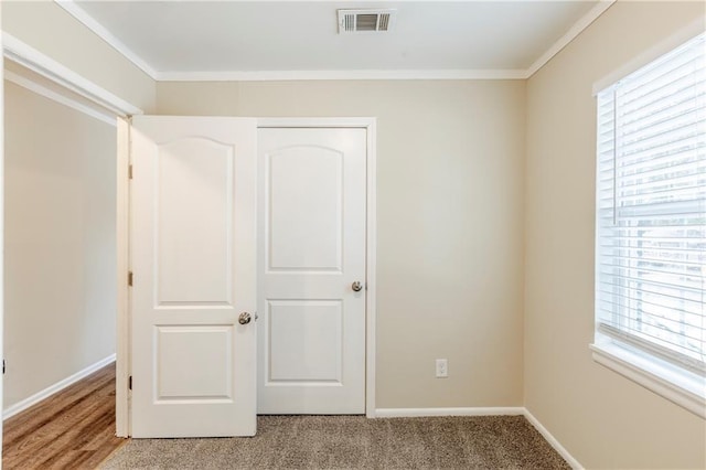 unfurnished bedroom with light carpet and crown molding