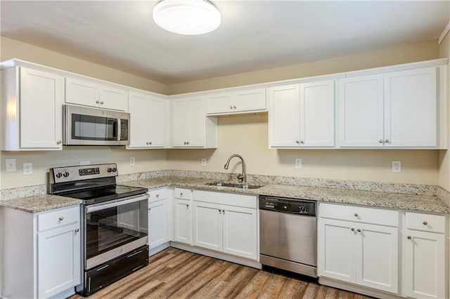 kitchen with stainless steel appliances, sink, and white cabinets