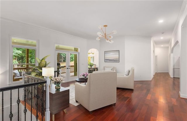 living room featuring french doors, a notable chandelier, crown molding, and dark hardwood / wood-style floors