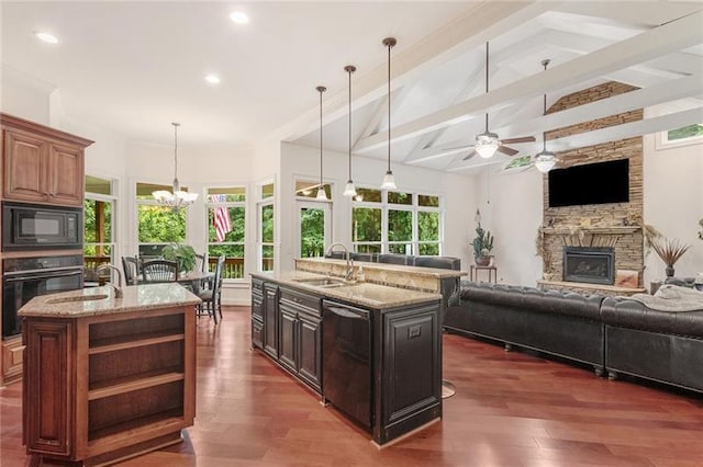 kitchen featuring dark hardwood / wood-style flooring, black appliances, a center island with sink, and sink