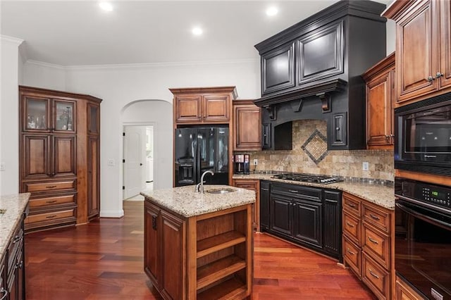 kitchen with dark hardwood / wood-style floors, a kitchen island with sink, tasteful backsplash, black appliances, and ornamental molding