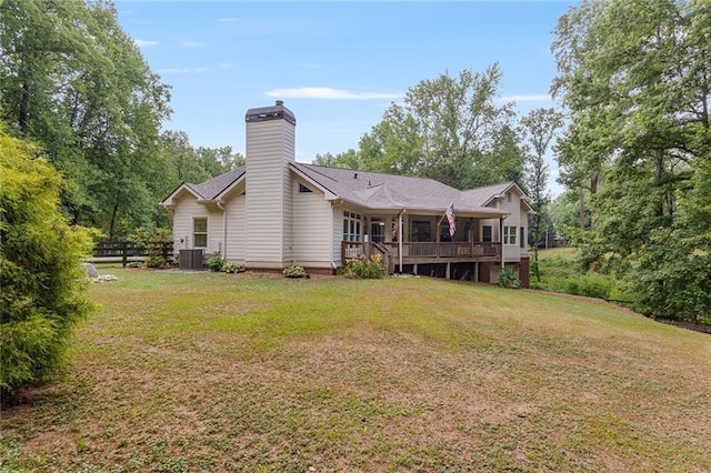 back of house with a wooden deck, central AC unit, and a lawn