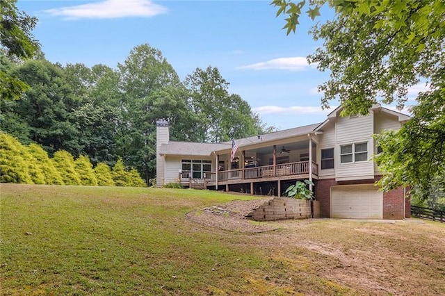 back of property with a lawn, a deck, and a garage