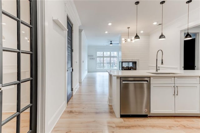 kitchen with white cabinetry, sink, ornamental molding, and stainless steel dishwasher