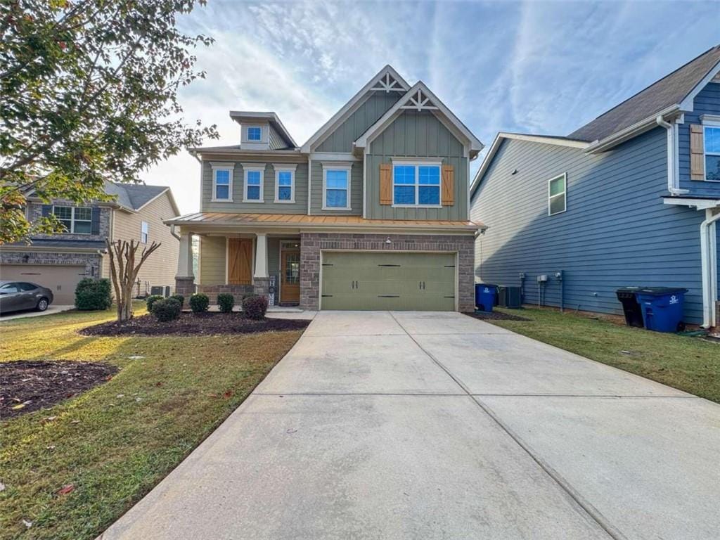 craftsman inspired home featuring a garage and a front yard