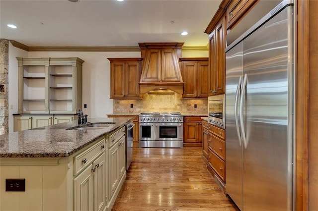 4853 Stonehall Pl, Atlanta, GA 30339 - kitchen with built in appliances, custom range hood, dark stone countertops, light wood-style floors, and decorative backsplash