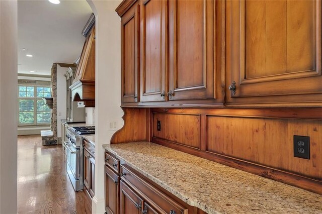 4853 Stonehall Pl, Atlanta, GA 30339 - kitchen with high end stainless steel range, brown cabinets, recessed lighting, light stone counters, and arched walkways
