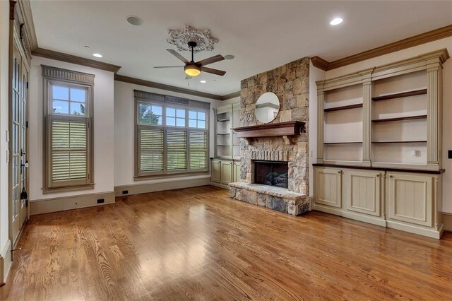 4853 Stonehall Pl, Atlanta, GA 30339 - unfurnished living room with crown molding, ceiling fan, a stone fireplace, wood finished floors, and baseboards