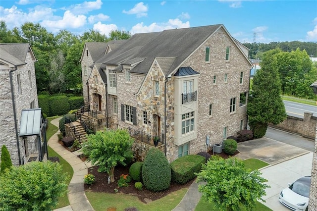 4853 Stonehall Pl, Atlanta, GA 30339 - view of property exterior featuring stone siding, a standing seam roof, central air condition unit, metal roof, and stairs