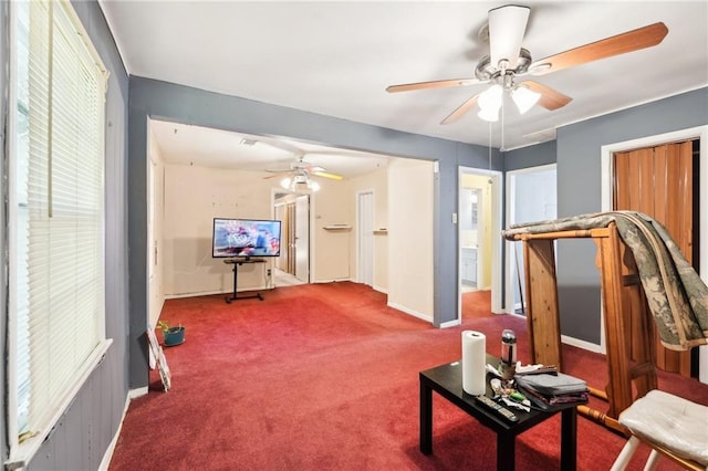 interior space featuring baseboards, carpet, and a ceiling fan