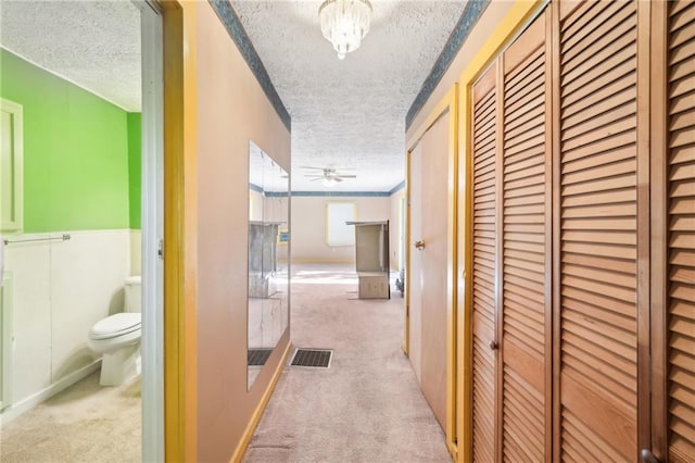hallway featuring carpet floors and a textured ceiling