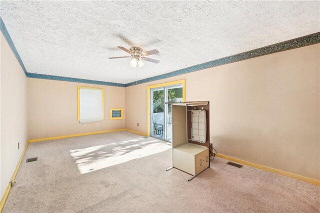 spare room with baseboards, a ceiling fan, carpet floors, and visible vents