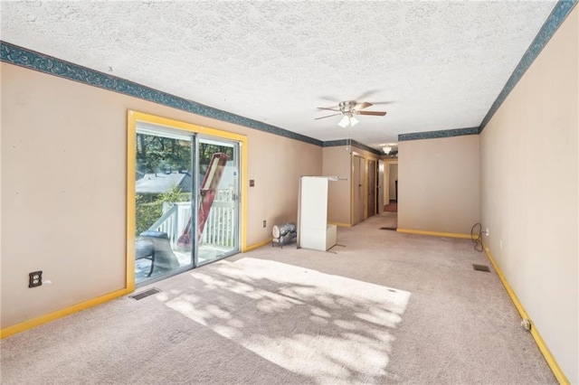 unfurnished room with carpet floors, a ceiling fan, and visible vents