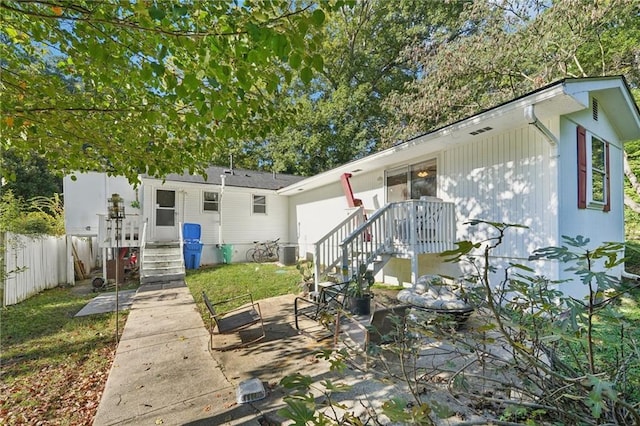 back of property with central air condition unit and fence