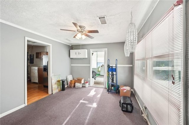 interior space featuring visible vents, a ceiling fan, carpet floors, and a healthy amount of sunlight