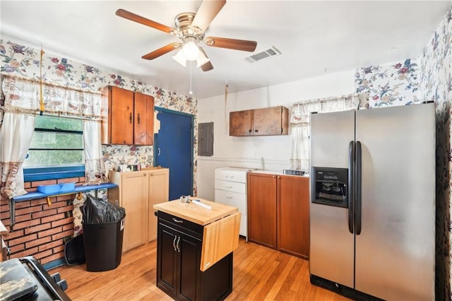 kitchen with wooden counters, a ceiling fan, wallpapered walls, stainless steel refrigerator with ice dispenser, and electric panel