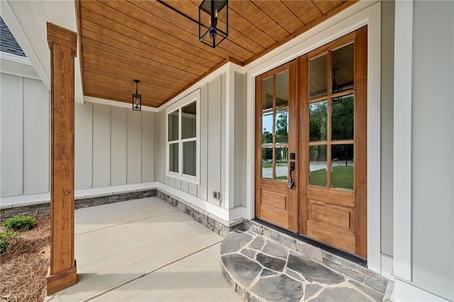 doorway to property featuring covered porch and french doors