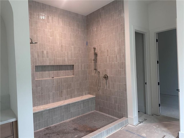 bathroom featuring concrete floors and tiled shower