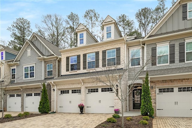 view of front of home featuring driveway, a garage, board and batten siding, and brick siding