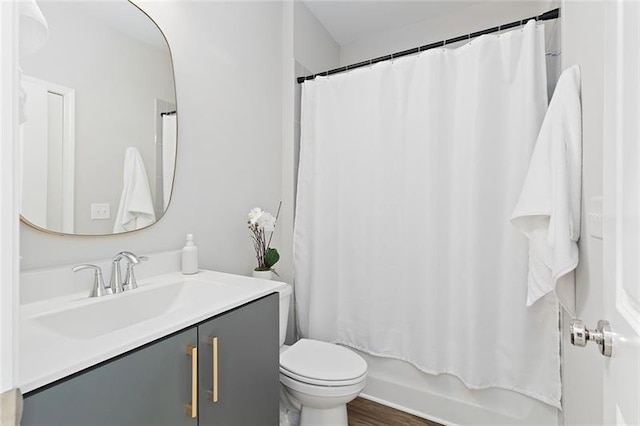 full bathroom featuring hardwood / wood-style floors, vanity, toilet, and shower / tub combo with curtain