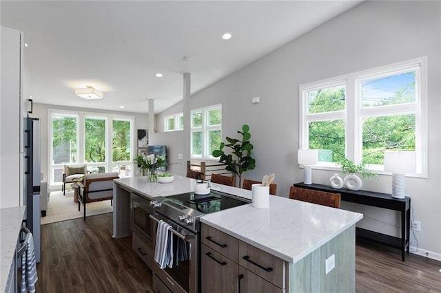 kitchen with electric stove, a kitchen island, a healthy amount of sunlight, and vaulted ceiling