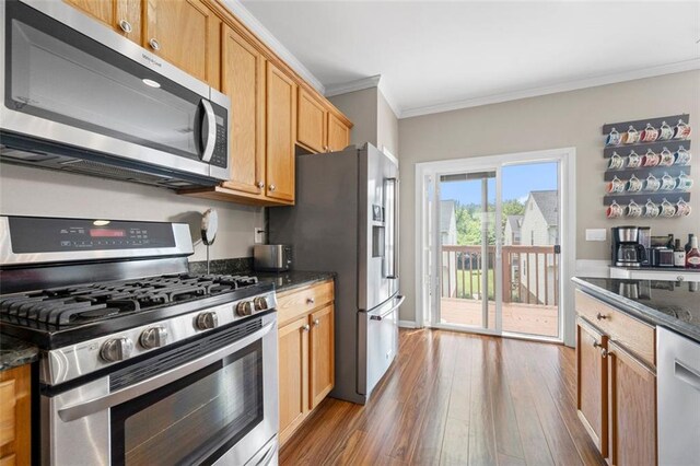 3542 Chattahoochee Summit Ln SE, Atlanta, GA 30339 - kitchen with stainless steel appliances, ornamental molding, wood finished floors, and dark stone counters