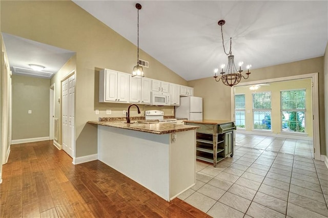 209 Jacobs Way, Jasper, GA 30143 - kitchen with white appliances, white cabinets, vaulted ceiling, decorative light fixtures, and a peninsula